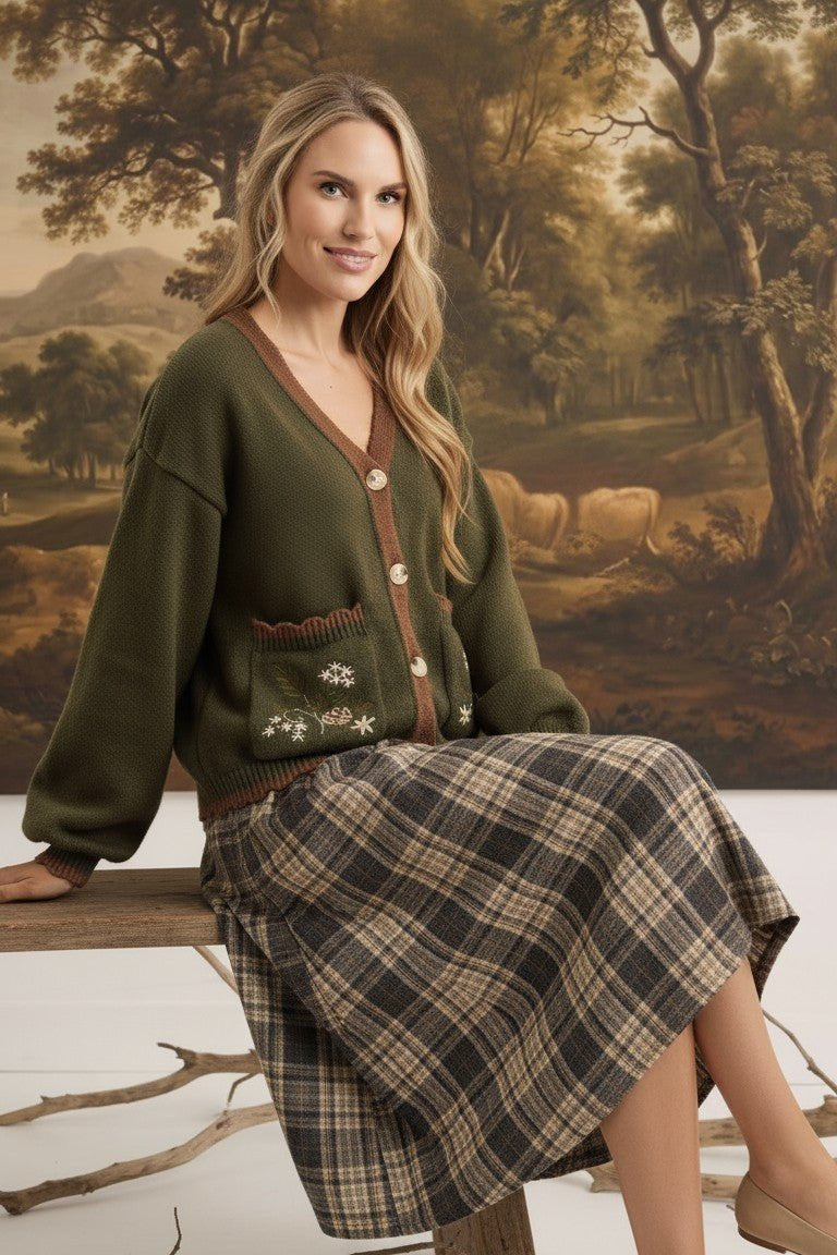 graced The Lola Pocket Detail Cardigan in olive green with floral embroidery, button front, and brown trim.