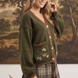 graced Lola cardigan in olive green with brown trim, button front, and embroidered pocket detail on a model