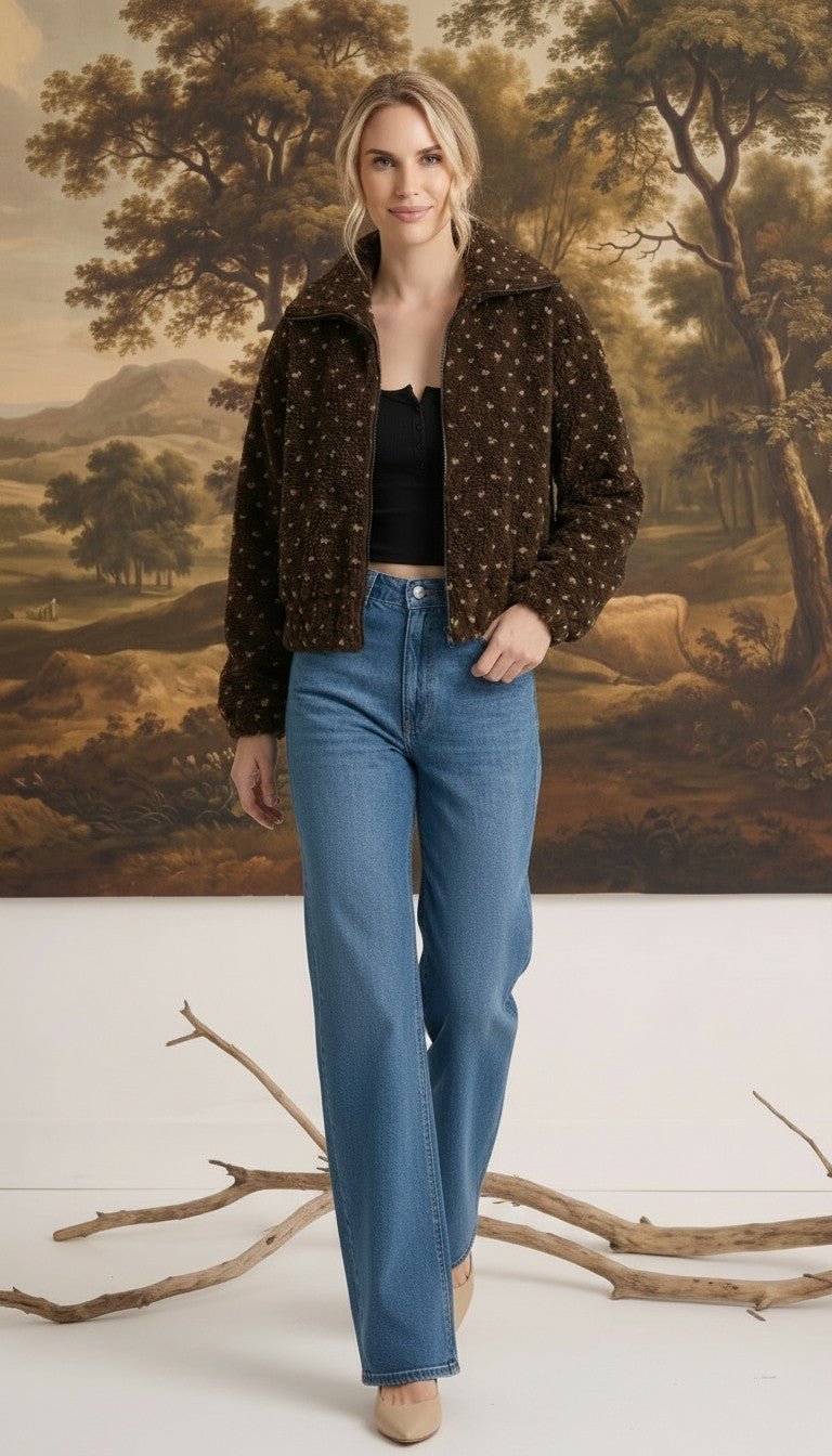 Model wearing a graced Lydia brown fleece jacket with a subtle star pattern, paired with blue jeans.