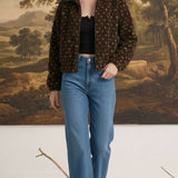 Model wearing a graced Lydia brown fleece jacket with a subtle star pattern, paired with blue jeans.