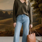 graced Lyn espresso brown V-neck batwing sweater worn by a smiling woman with light blue jeans and a tan tote bag