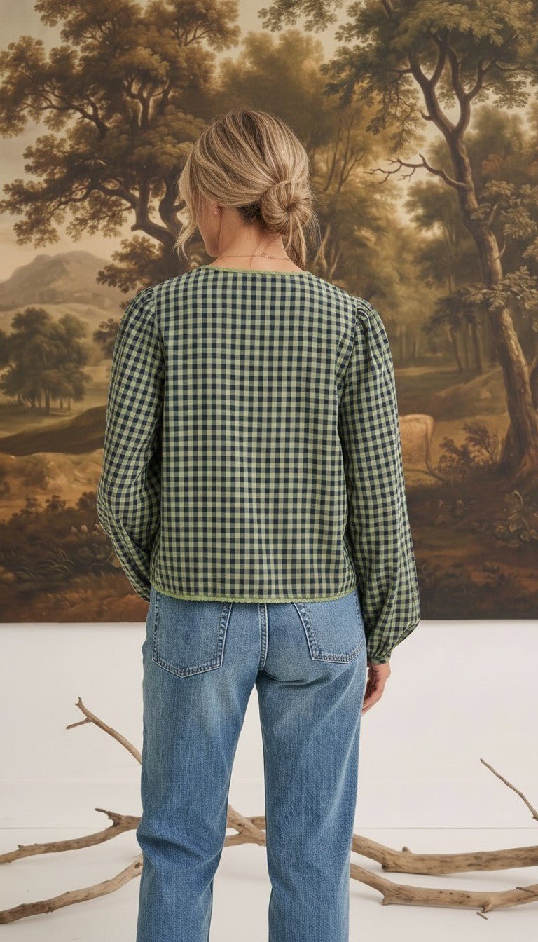 Back view of a woman wearing the graced Madilynne Gingham Top in green and black with long sleeves and lace trim.