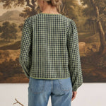 Back view of a woman wearing the graced Madilynne Gingham Top in green and black with long sleeves and lace trim.