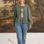 Model wearing graced Madilynne Gingham Top in green with long sleeves, lace trim, and a tie neckline over blue jeans