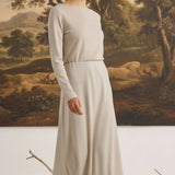 graced The Margo wool midi skirt in beige worn by a blonde model in a long-sleeved matching top against a landscape