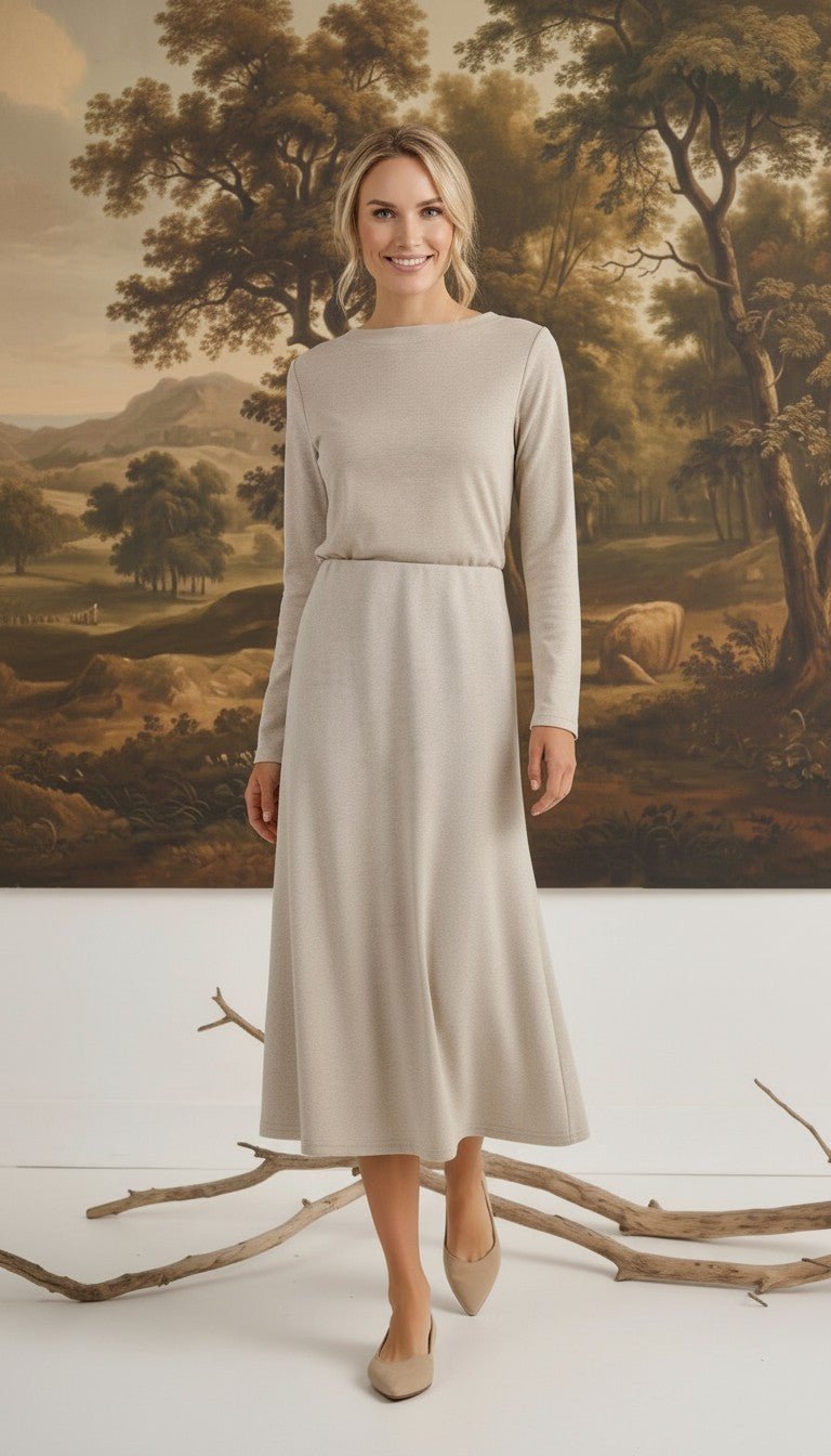 graced model wearing a beige wool-blend midi skirt and long-sleeve top in a studio with a landscape painting backdrop