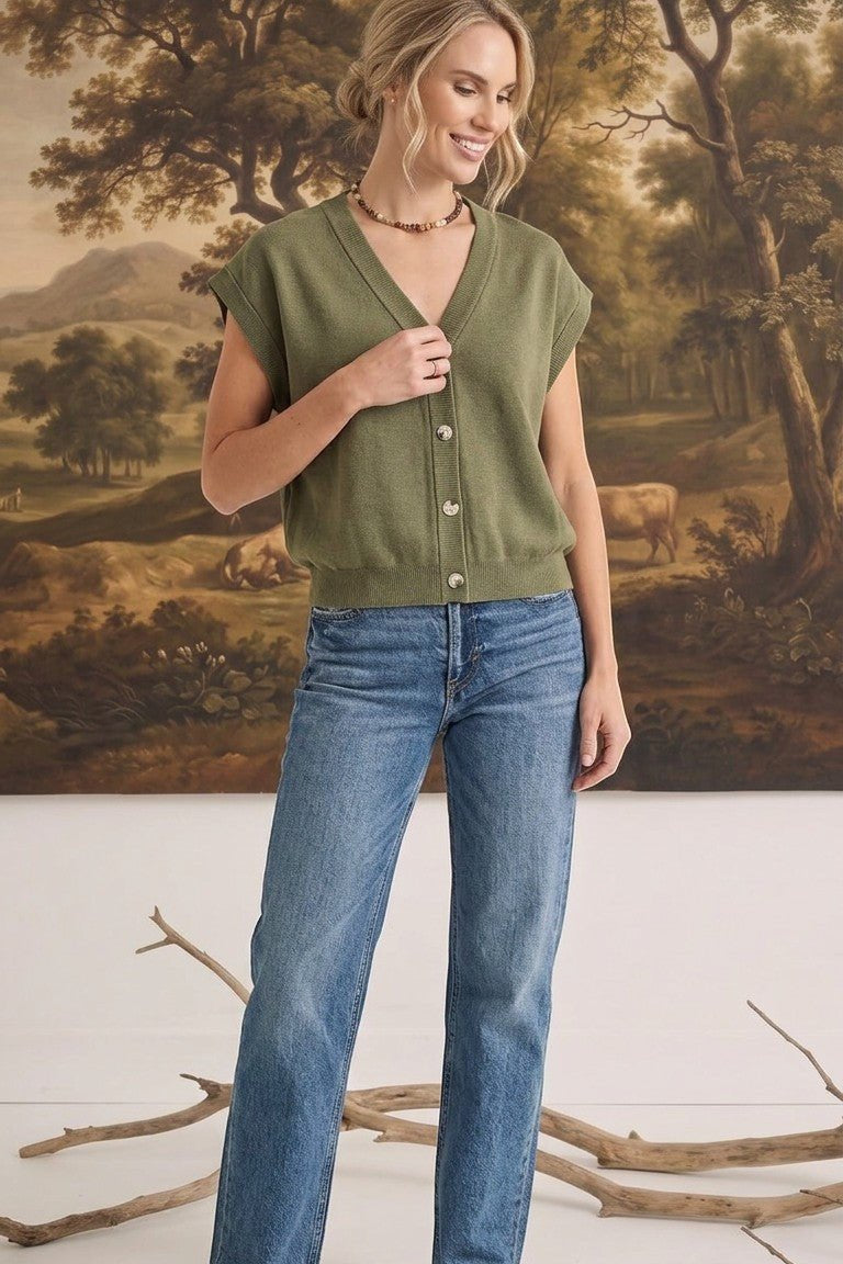 graced model wearing an olive green sleeveless cotton button-down top with blue jeans in a studio setting