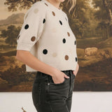 graced Michelle knit top in cream with multi-color polka dots, short sleeves, and a relaxed fit on a female model