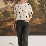 graced Michelle knit top in cream with multi-color polka dots, short sleeves, and relaxed fit worn with dark jeans.