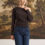 graced chocolate brown off-the-shoulder top with long sleeves worn by a woman with blue jeans