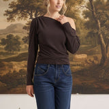 graced chocolate brown off-the-shoulder top with long sleeves worn by a woman with blue jeans