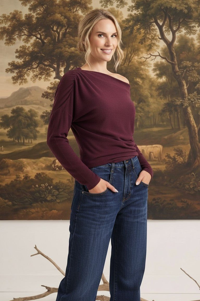 graced winetasting off the shoulder top with long sleeves worn by a blonde model with dark blue jeans