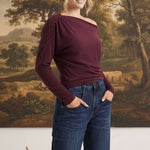 graced winetasting off the shoulder top with long sleeves worn by a blonde model with dark blue jeans