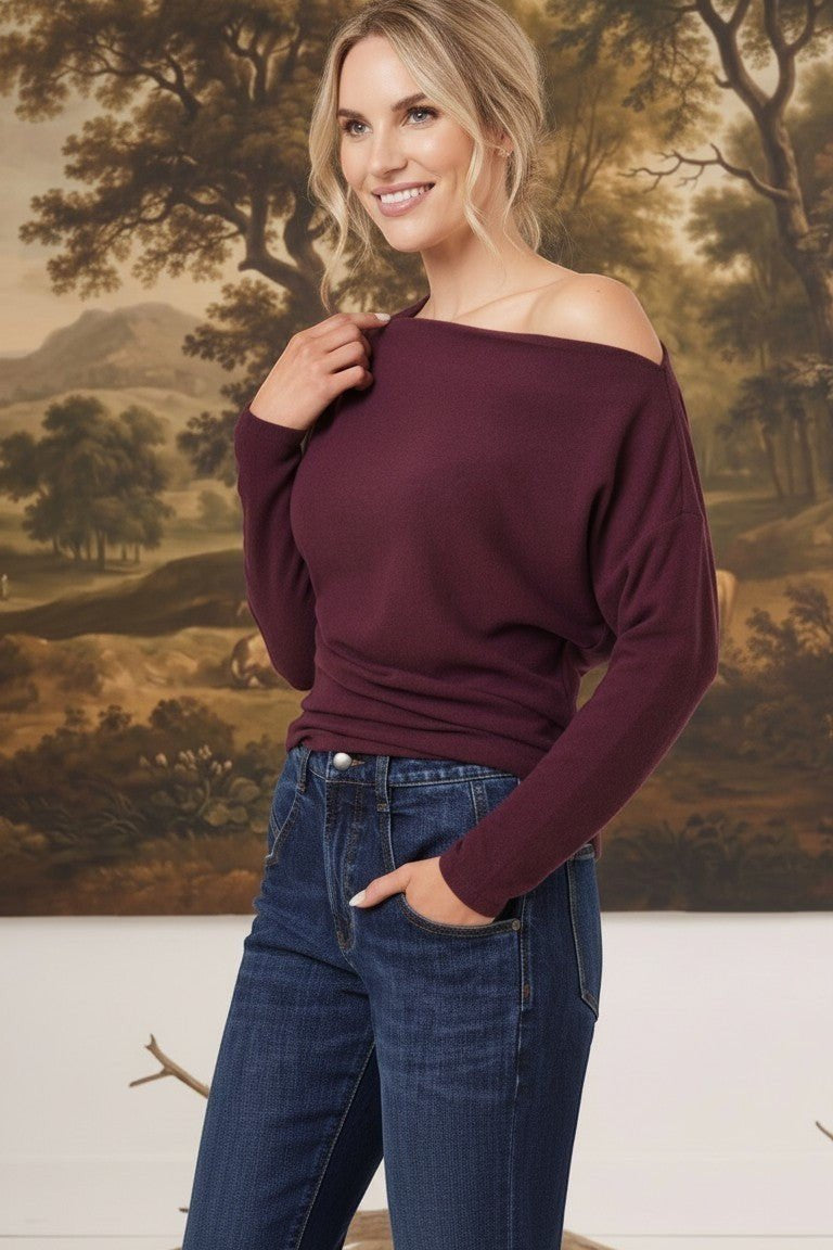 graced winetasting off the shoulder top with long sleeves worn by a smiling blonde model with dark blue jeans
