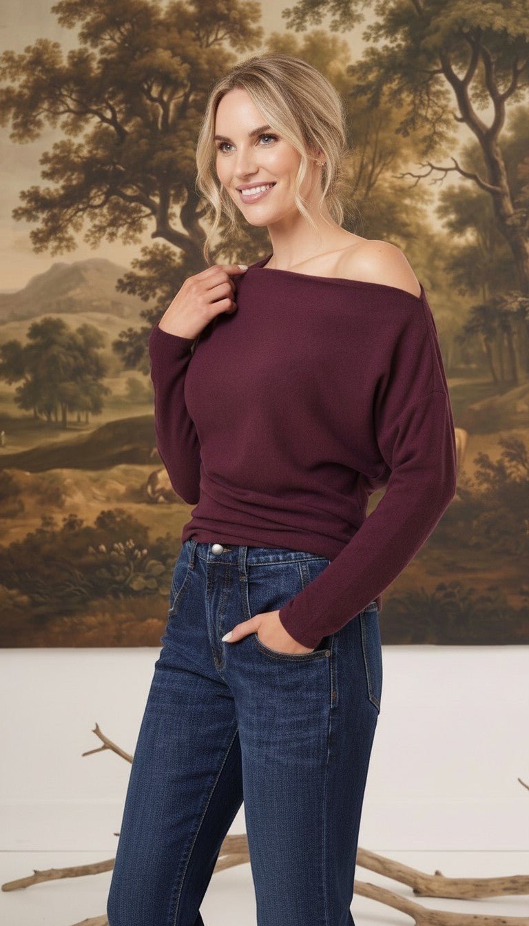 graced winetasting off the shoulder top with long sleeves worn by a smiling blonde model with dark blue jeans