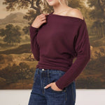 graced winetasting off the shoulder top with long sleeves worn by a smiling blonde model with dark blue jeans