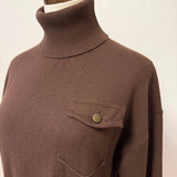 graced brown turtleneck sweater featuring a single chest pocket with a metal button on a mannequin