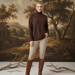 graced Remy brown turtleneck sweater with a chest pocket, worn by a woman with beige riding pants and brown boots