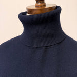 graced Remy navy blue turtleneck sweater on a mannequin featuring a ribbed collar and soft blended knit fabric