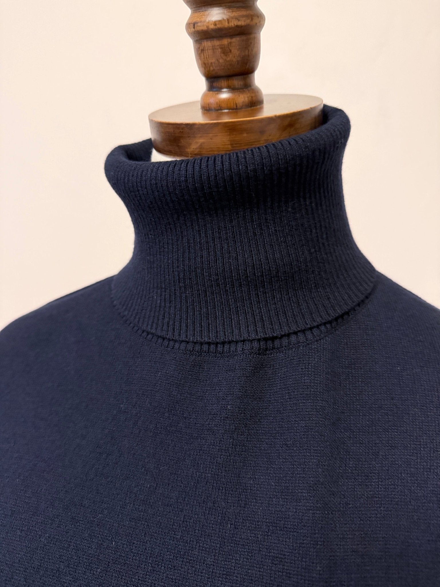 graced Remy navy blue turtleneck sweater on a mannequin featuring a ribbed collar and soft blended knit fabric