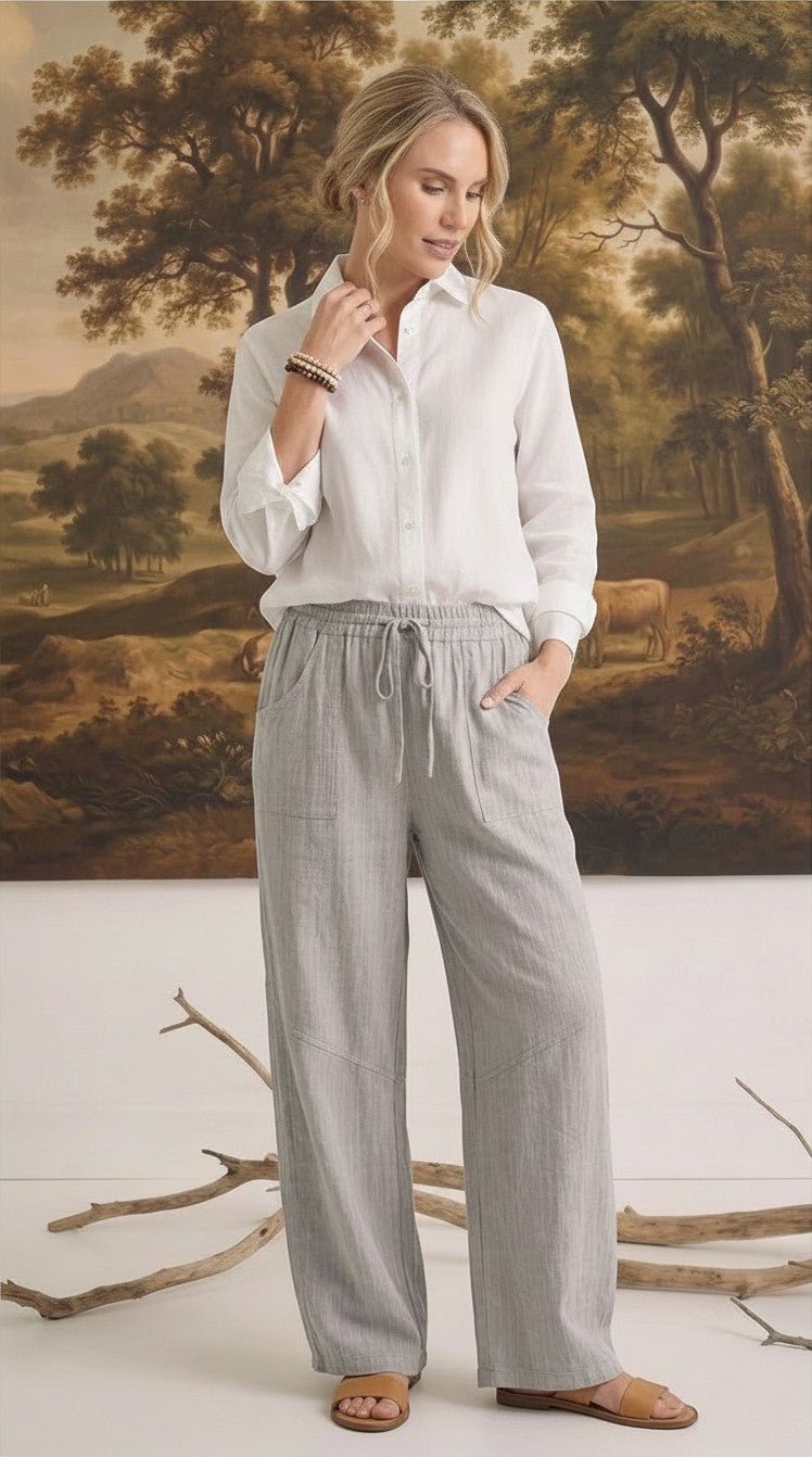 graced The Rita relaxed grey striped pants in a rayon-linen blend with a drawstring waist, worn with a white shirt.