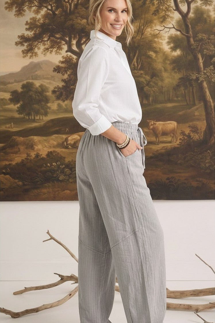 graced The Rita relaxed grey striped pants in a rayon-linen blend worn by a woman with a white button-down shirt