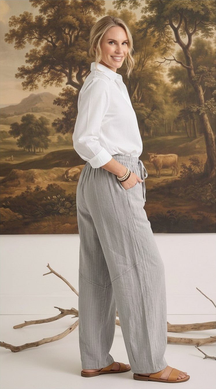graced The Rita relaxed grey striped pants in a rayon-linen blend worn by a woman with a white button-down shirt