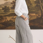 graced The Rita relaxed grey striped pants in a rayon-linen blend worn by a woman with a white button-down shirt