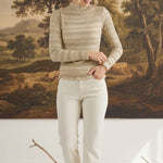graced The Tatum oatmeal long-sleeve top with lettuce-edge trim worn by a model against a landscape painting backdrop