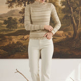 graced The Tatum oatmeal long-sleeve top with lettuce-edge trim worn by a model against a landscape painting backdrop
