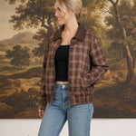 graced Tessa bomber jacket in brown plaid with leather collar, worn by a woman with jeans and a black top