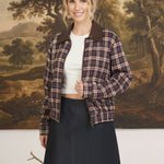 graced Tessa burgundy plaid bomber jacket with leather collar worn by a smiling model in front of a landscape mural