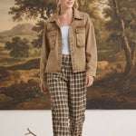 Model wearing graced The Tina Plaid Checker Pants in brown and white with a tan denim jacket in a studio setting.