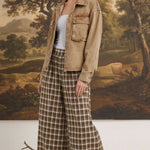 graced model wearing brown and white plaid checker wide-leg pants with a tan denim jacket and platform sandals