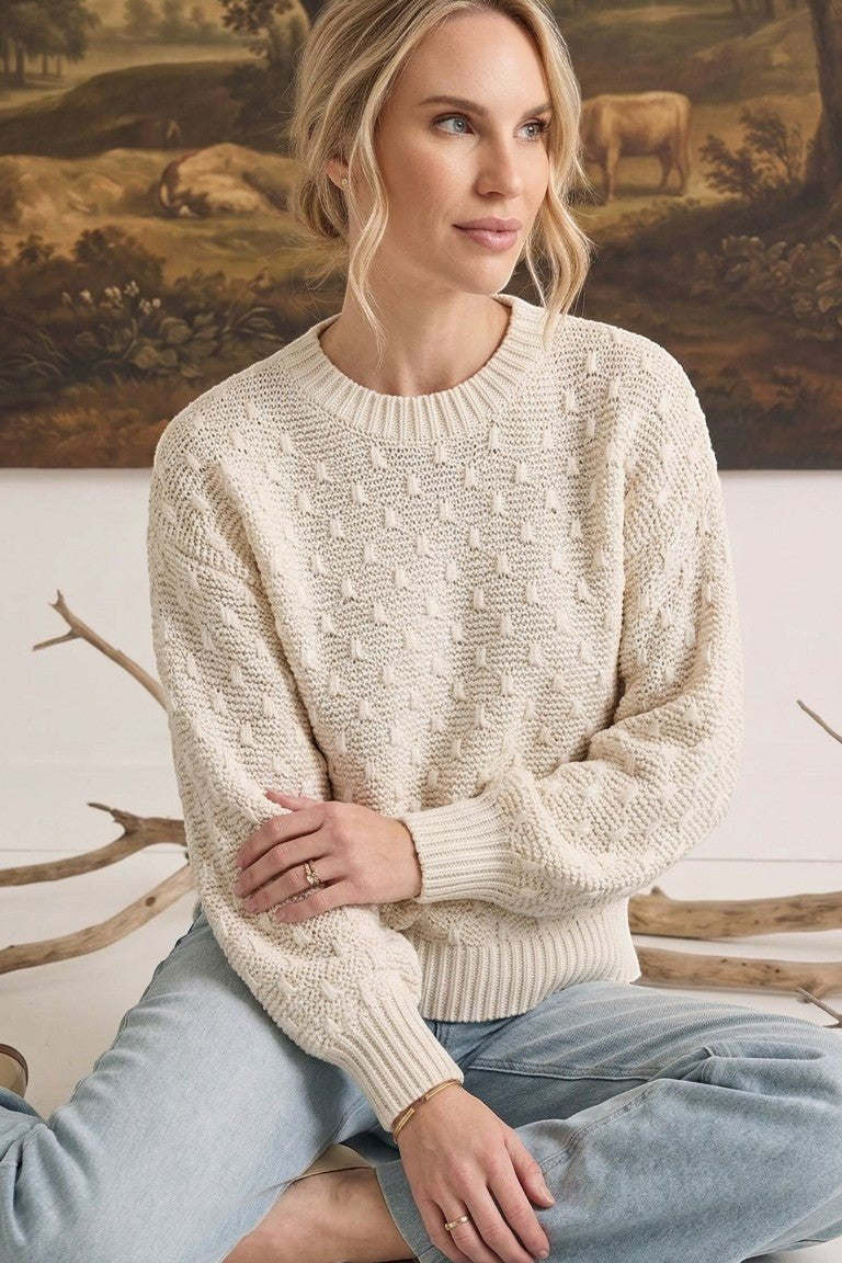 graced cream two-tone textured weave sweater with a crew neck and relaxed fit worn by a woman with light hair