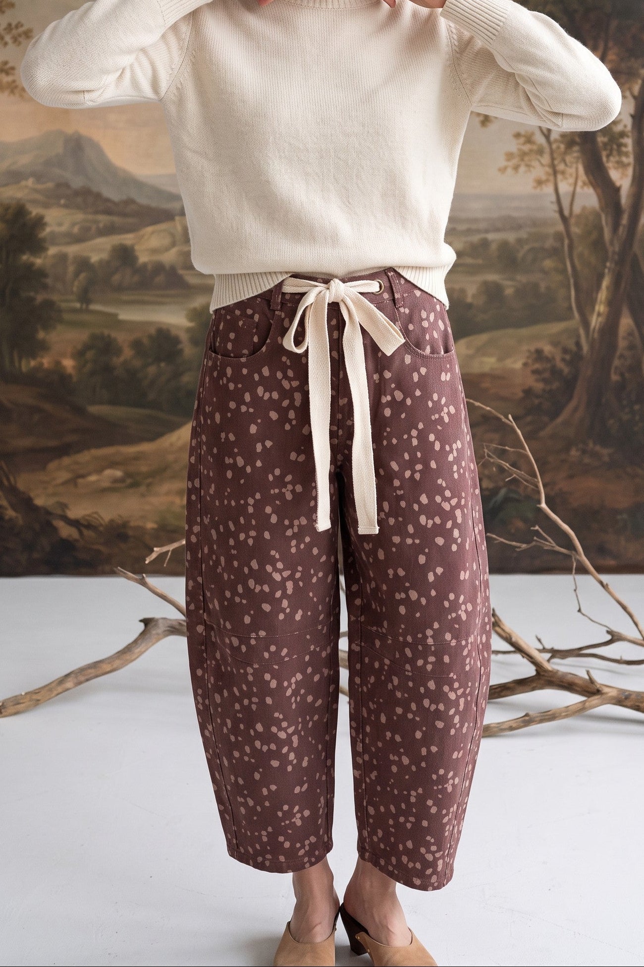 graced chocolate-brown barrel pants with a spotted Bambi print, featuring a contrasting cream bow-tie waist.