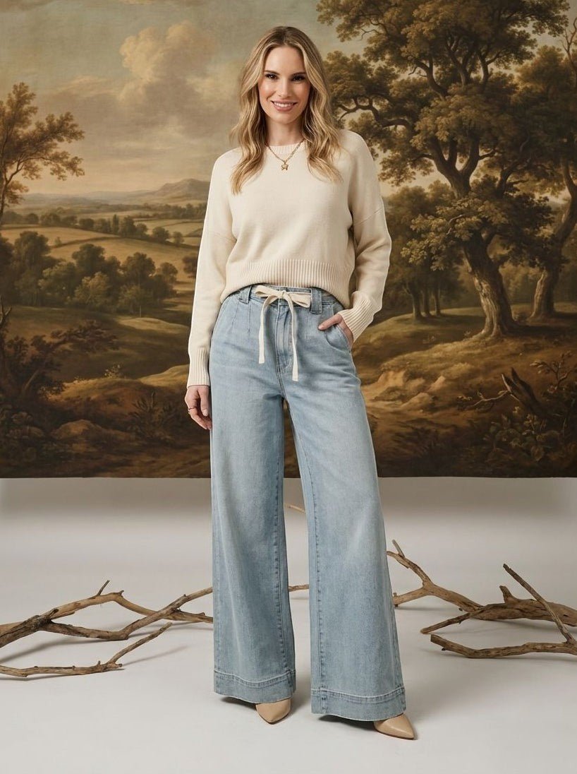 graced washed denim tie-front pants in light blue with a relaxed wide-leg fit worn by a model with a cream sweater