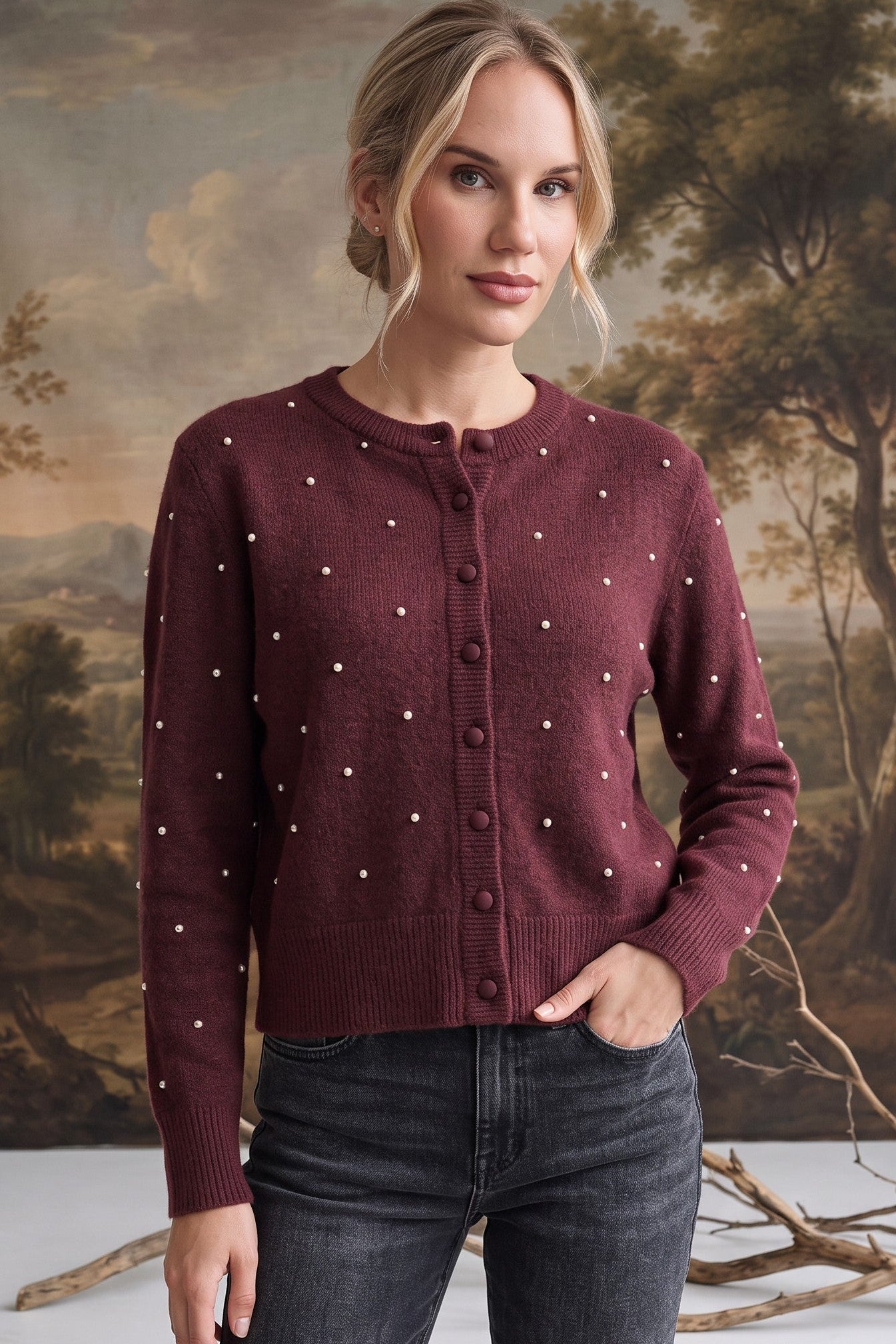 A model wearing a graced burgundy wool-blend cardigan with cream dots, crew neck, and tonal buttons over dark jeans.